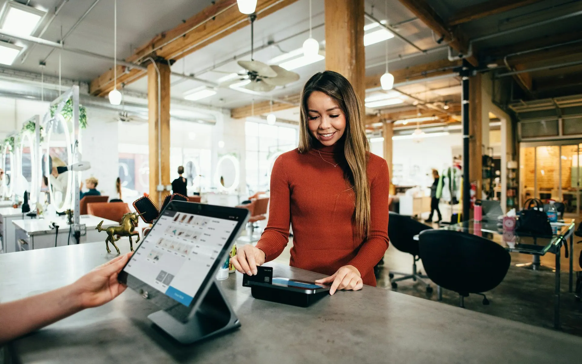Shop assistant taking a contactless payment on a tablet point-of-sale