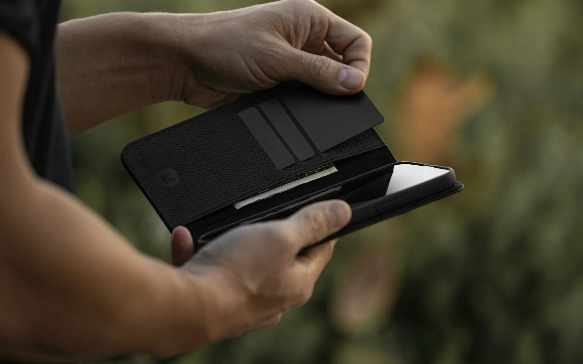 Hands opening a wallet holding payment cards