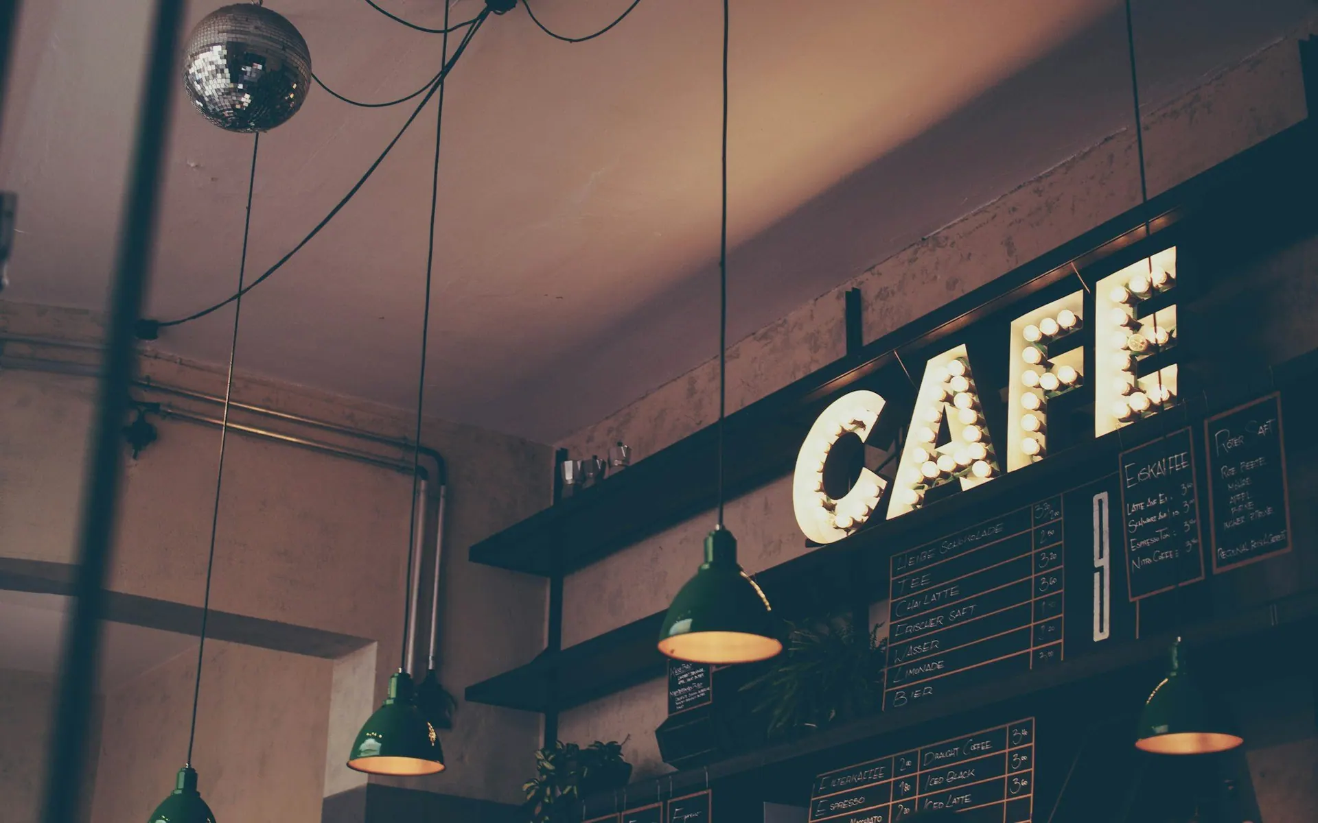Illuminated CAFE sign above a coffee shop entrance