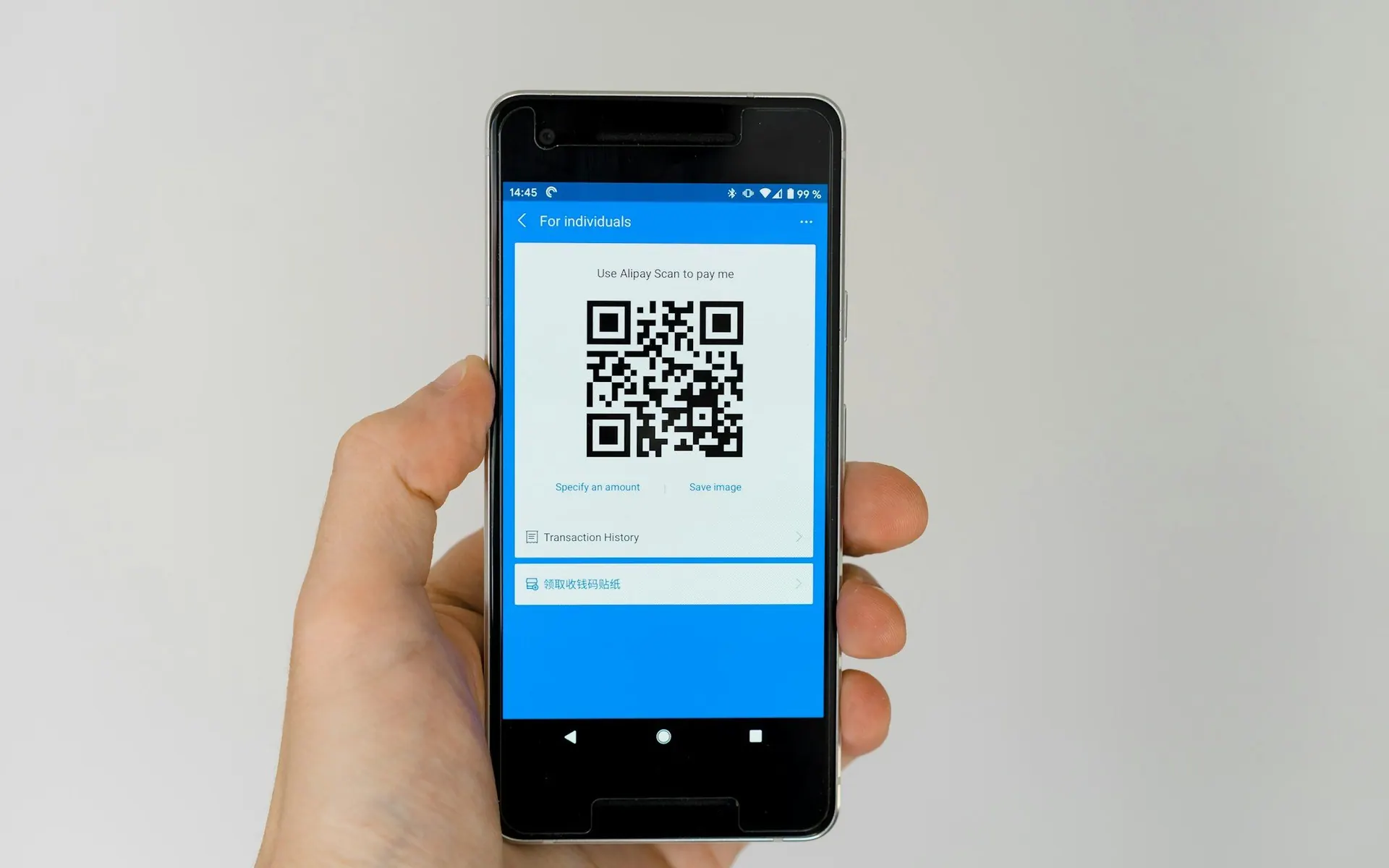 Hand holding a smartphone scanning a QR code