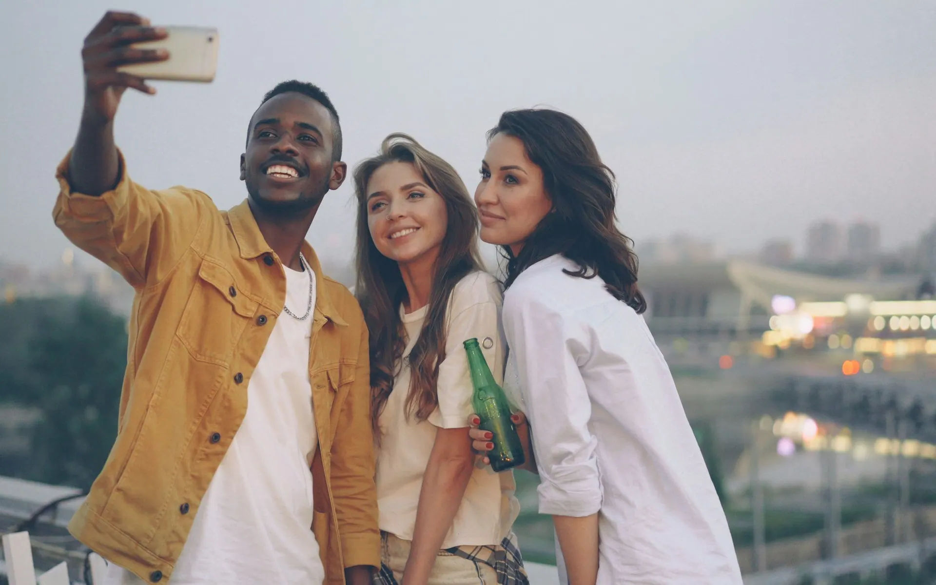 Three friends taking a selfie together in the city